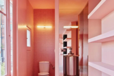 25 a whimsy bathroom done in salmon pink, with built-in shelves and windows to floof the space with natural light