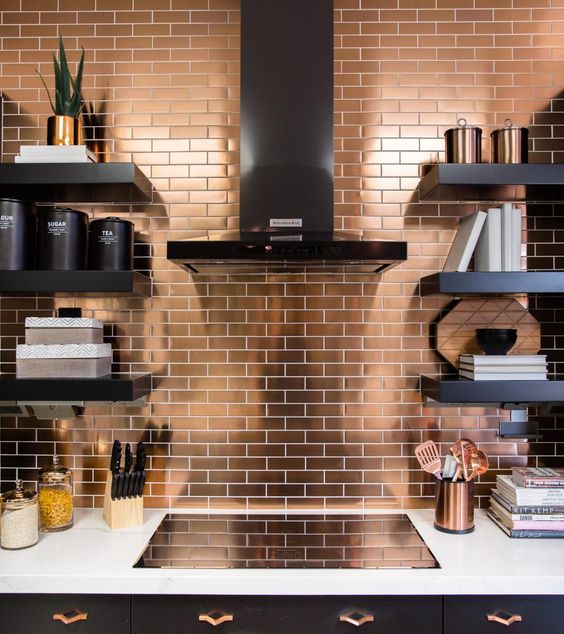 a modern black kitchen with a white countertop and a copper tile backsplash for a bright and shiny accent