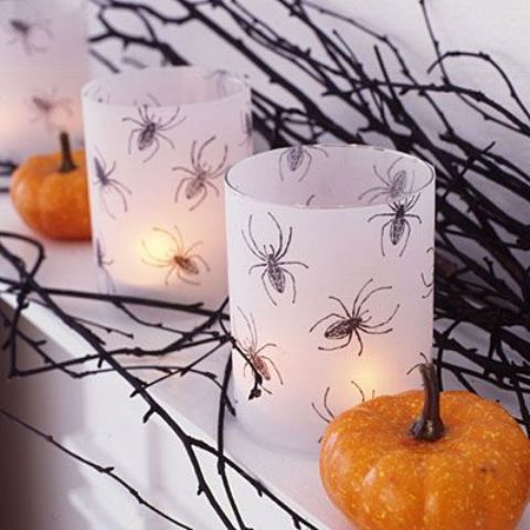 white candleholders with spiders drawn are a chic and simple DIY idea for Halloween decor