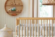 a mid-century modern nursery in neutrals, with wooden furniture, a basket and a round shelf