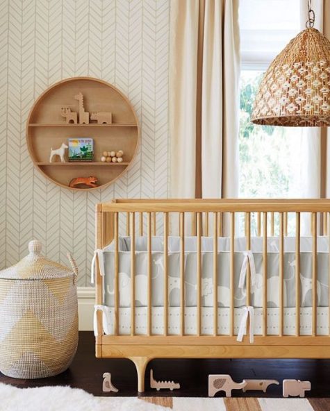 A mid century modern nursery in neutrals, with wooden furniture, a basket and a round shelf