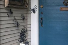 paper spiders on the walls, black and white pumpkins, a spiderweb wreath and a sign for simple and fast Halloween decor