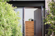 02 The front door is clad with dark wood and it’s pivoting, which gives a modern feel to the space