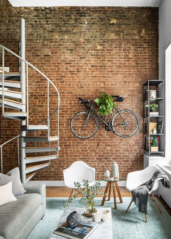an exposed brick wall with a bike shelf on it is a great industrial touch to this contemporary space