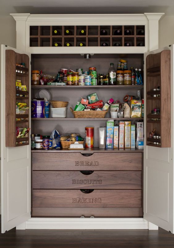 a stylish built-in pantry with neutral doors and darker stained built-ins - shelves, drawers and built-in shelves