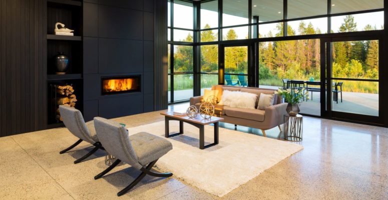 The living room is done with a built-in fireplace, a glazed wall and some stylish furniture