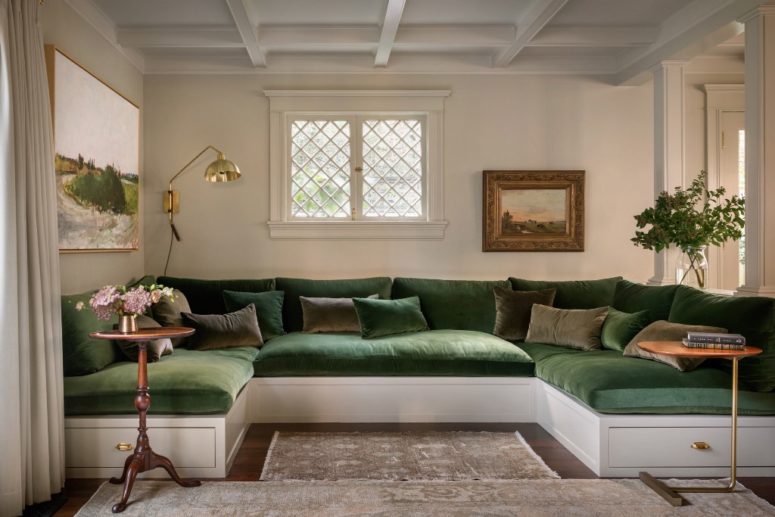 This is a chic conversation zone with a U-shaped sofa and brass touches that features greens