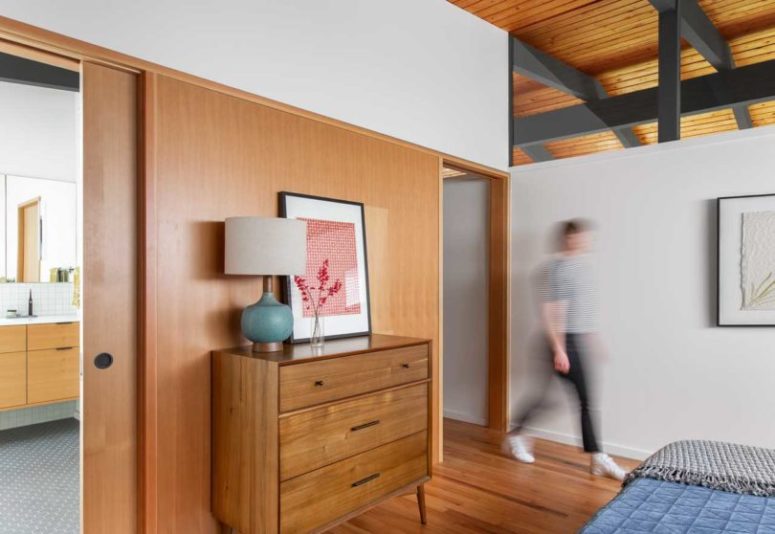 The master bedroom is decorated simply, with stylish mid-century modern furniture and blue textiles