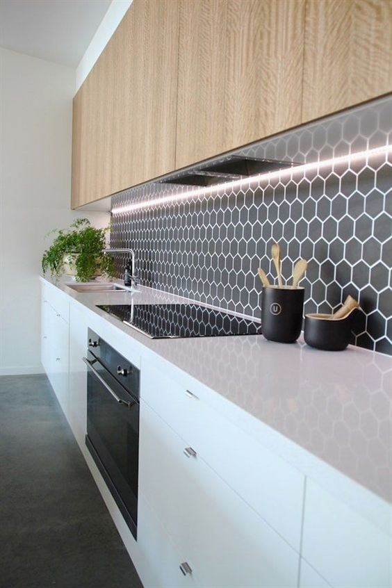 a minimalist black backsplash with small hexagon tiles highlighted with white grout
