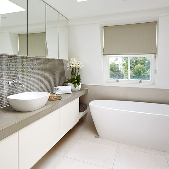 a stylish neutral bathroom with grey shades and touches here and there and a grey tile backsplash
