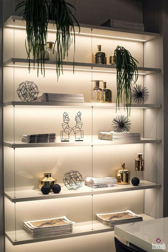 a wall shelving unit lit up with built-in lights is a cool idea to make your objects on display at their best