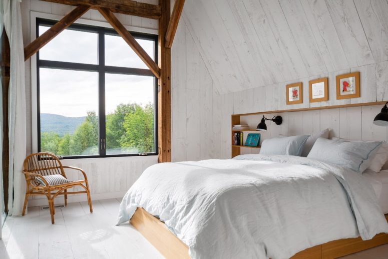 The bedroom features a built-in headboard, a bed, some floatign shelves and a large window
