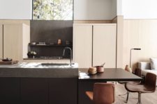 07 The kitchen is done with sleek light-colored cabinets, a dark kitchen island and brown chairs