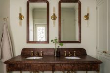 08 The bathroom features a dark walnut wooden vanity with brass touches and a duo of mirrors