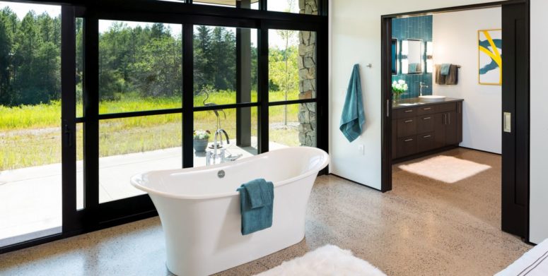 There's a free-standing tub by a glazed wall, with an advantage of the scenery