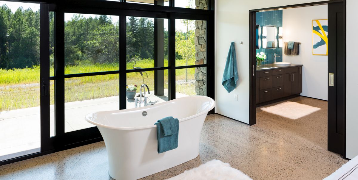 There's a free standing tub by a glazed wall, with an advantage of the scenery