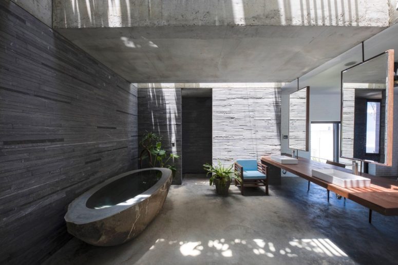 There's also an indoor-outdoor bathroom with a carved stone tub and a large floating vanity with mirrors