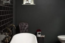 10 a stylish dark and moody bathroom with a shiny black tile wall and all matte everything plus a black tub