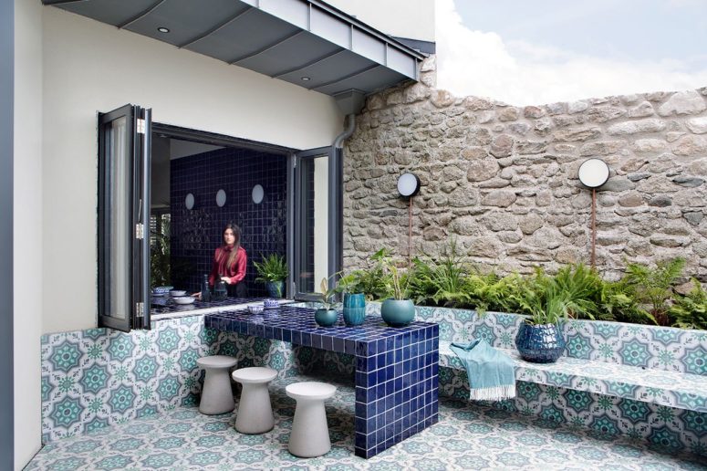 The terrace is done in Moroccan boho style, with printed tiles and lots of greenery