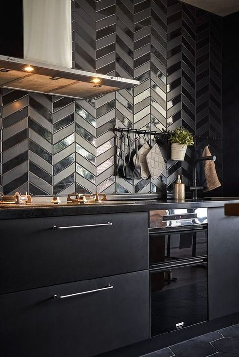 A very eye catchy herringbone tile backsplash in matte and shiny finishes is very bold