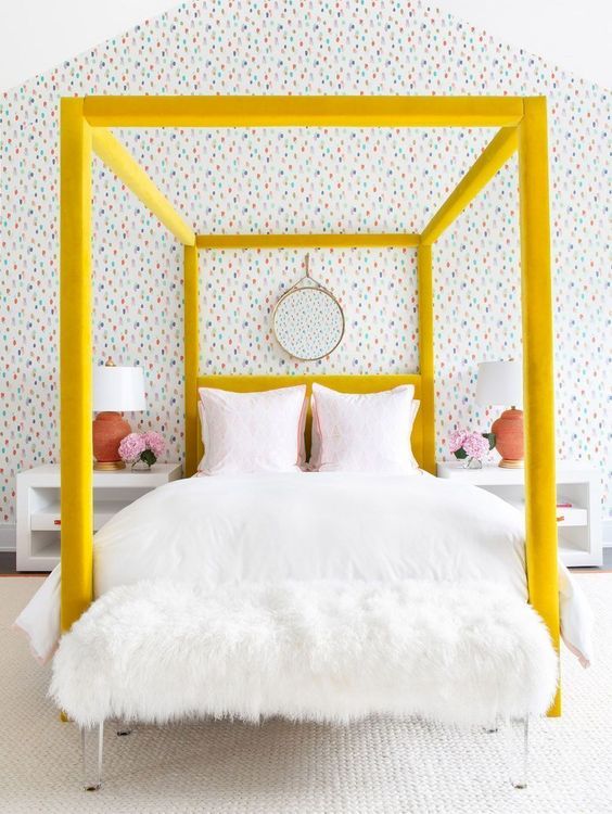 a bold yellow velvet upholstered canopy bed is a colorful statement in the bedroom that brings cheer