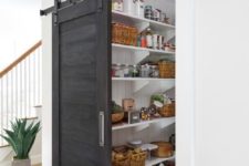 13 a farmhouse pantry with a dark sliding door, which doesn’t take any space and makes a statement with its color