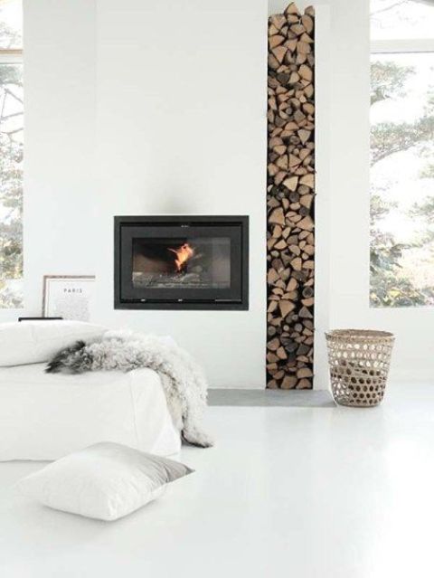 A minimalist built in fireplace with a tall and narrow firewood storage space looks very edgy