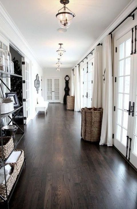 a neutral space with a dark hardwood floor that makes it look expensive and very stylish, and baskets add coziness
