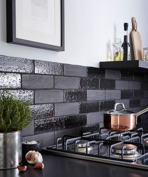 a black backsplash done with shiny and matte faux bricks is a cool and fresh modern idea to try