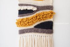 15 a crochet wall hanging in neutrals, mustard and black looks catchy and cool