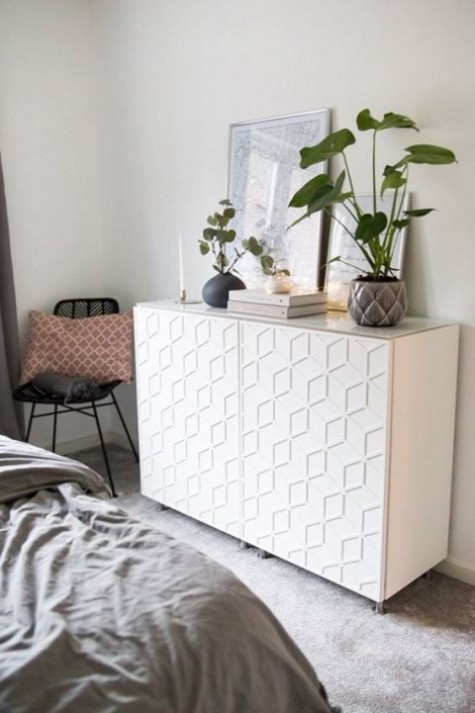 an IKEA Metod cabinet decorated with modern and bold front decor panels is a cool idea for a contemporary bedroom