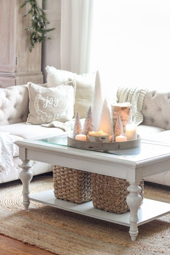 a neutral living room with white winter pillows, a tray with snowy Christmas trees and candles looks cute and chic