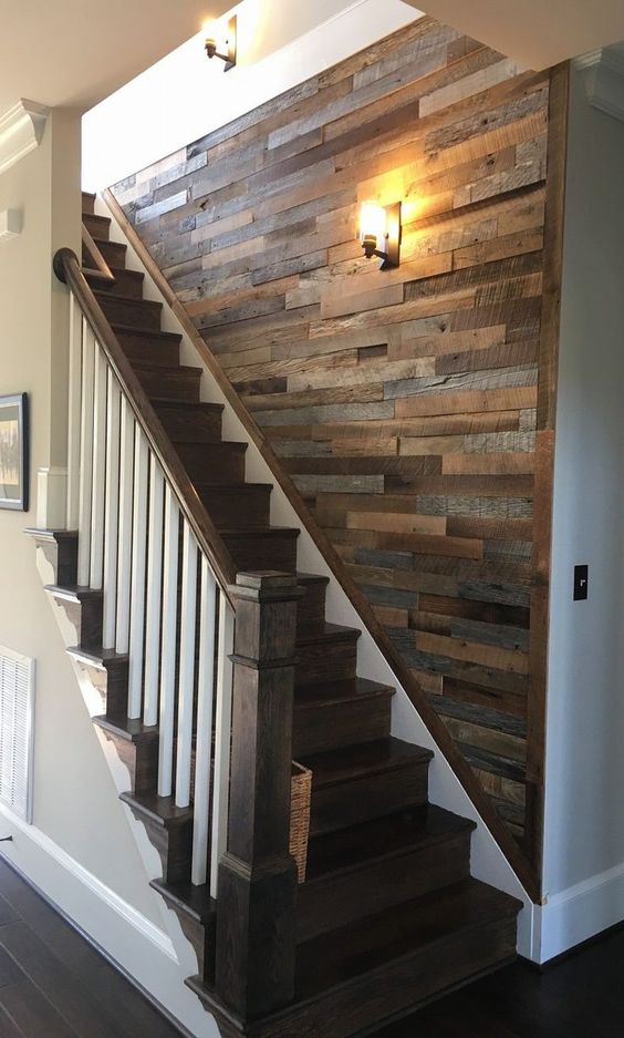 a reclaimed wooden wall over the staircase is a cool way to add interest to this blank wall and make the space cozy