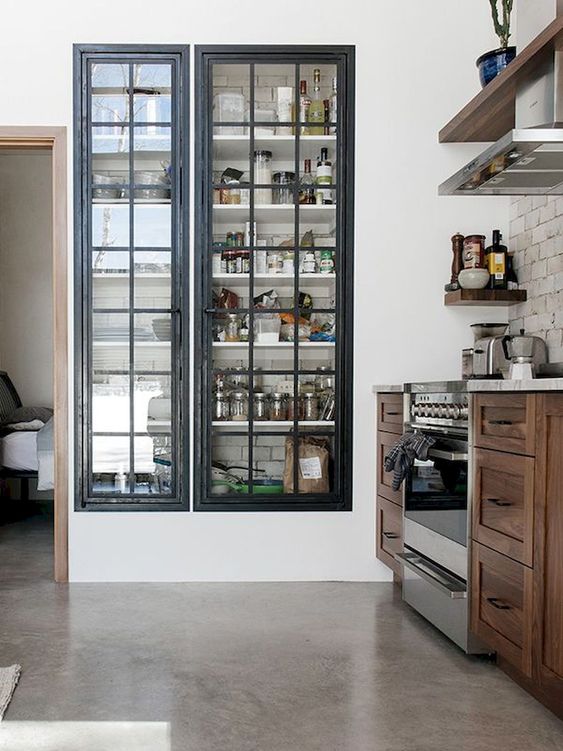 A built in pantry with framed glass doors that keep it in order but allow you see what's inside