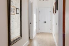 18 a chic entryway donen with neutral and warm hardwood floors, refined vintage mirrors and chandeliers