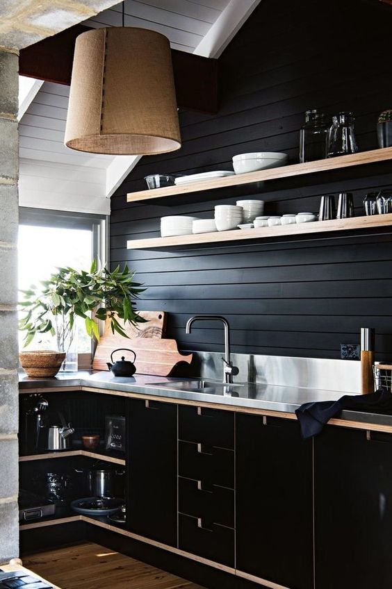 a black shiplap backsplash is a budget-friendly idea that matches the black plywood cabinets and a metal countertop
