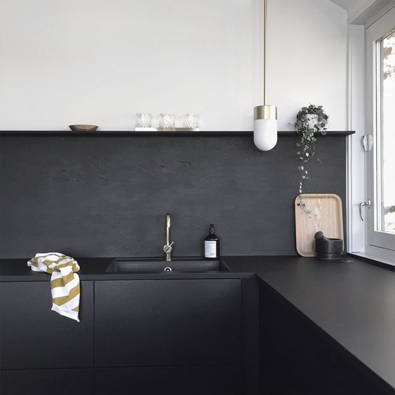a matte black painted backsplash is a low cost idea and it continues the decor of the kitchen with black cabinets and countertops