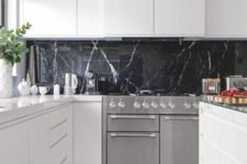23 a pure white minimalist kitchen with a black marble backsplash that adds a refined and chic touch
