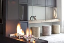 24 a dark tile clad fireplace with a glass hood is a super spectacular and refined idea for your home