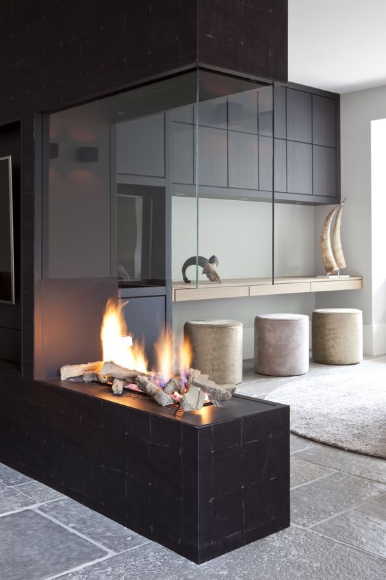 a dark tile clad fireplace with a glass hood is a super spectacular and refined idea for your home