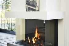 25 a modern fireplace with a concrete platform encased in glass is a very chic and refined idea with a modern feel