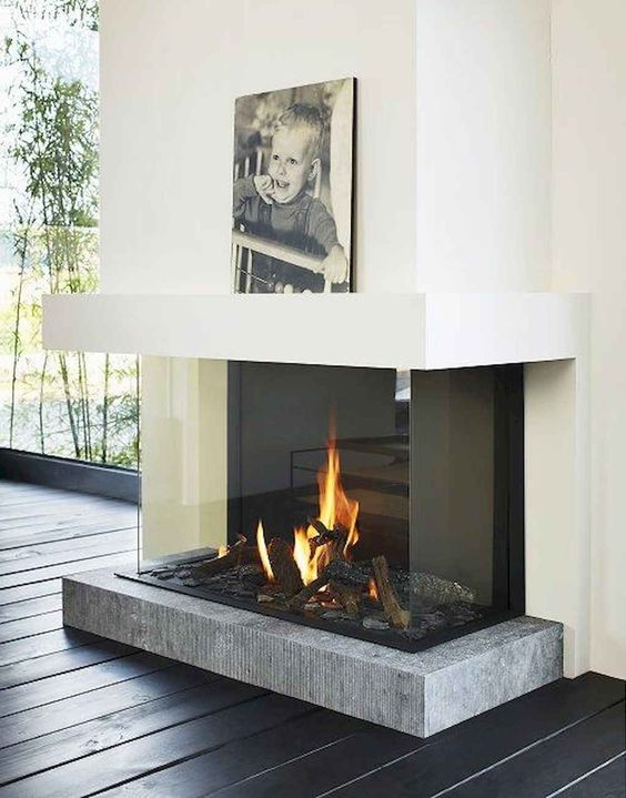 a modern fireplace with a concrete platform encased in glass is a very chic and refined idea with a modern feel