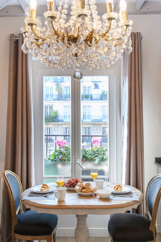 make your breakfast nook ultimately elegant with a large vintage crystal chandelier and chic furniture