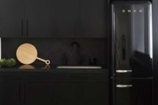25 matte black cabinets, a matte black backsplash and a black shiny fridge for an edgy moody kitchen