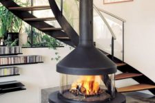 26 a stylish and cute glass encased fireplace with a dark metal hood will cozy up any space and highlight your staircase