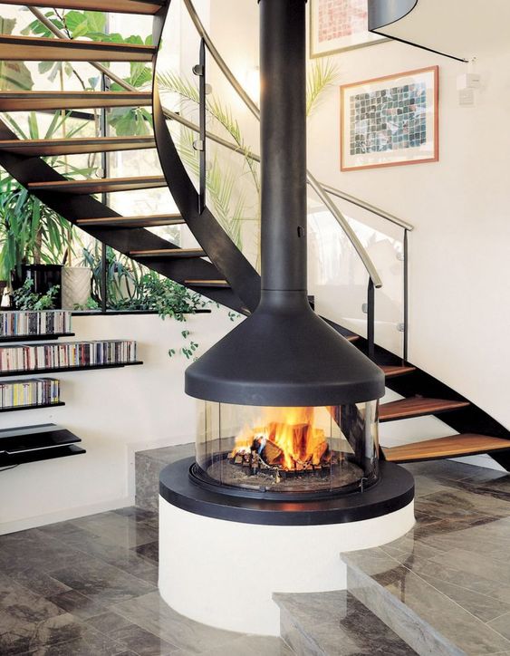 a stylish and cute glass encased fireplace with a dark metal hood will cozy up any space and highlight your staircase