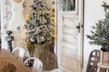 26 neutral farmhouse dining room decor with evergreens, a flocked Christmas tree with lights, an ornament garland and a basket