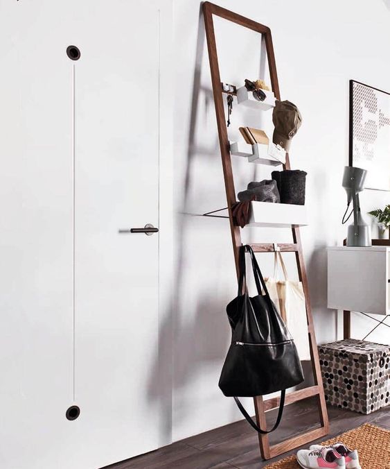 a modern ladder with bags on it and soem storage containers for small stuff is ideal for an entryway