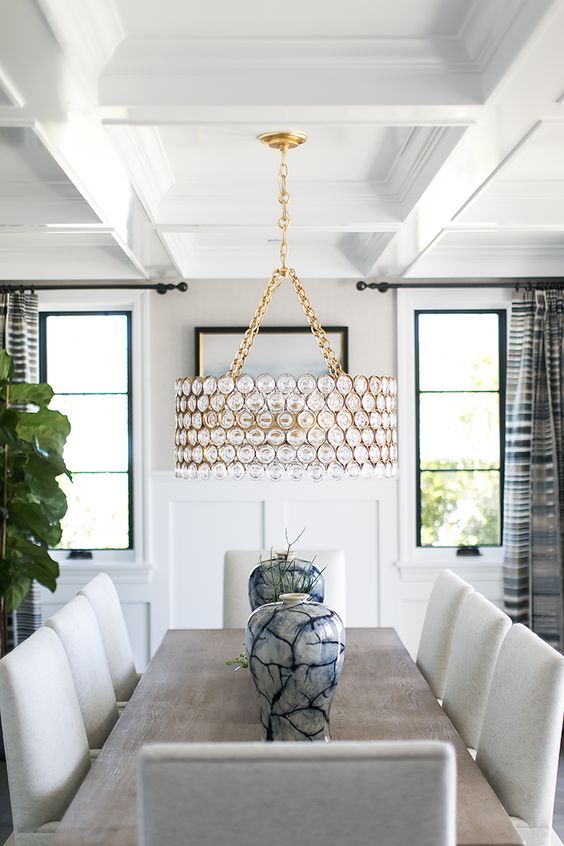 A dining space spruced up with a designer chandelier on gold chains for a sparkly touch