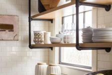31 a wall-mounted shelving unit of black pipes and wood is a stylish idea for adding an industrial touch to the kitchen